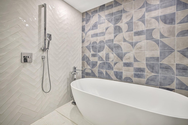bathroom featuring a freestanding tub, tile patterned floors, a tile shower, and tile walls