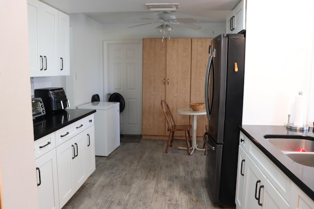 1020 NW 74th Ave, Margate, FL 33063 - kitchen featuring freestanding refrigerator, dark countertops, light wood-type flooring, white cabinetry, and a ceiling fan