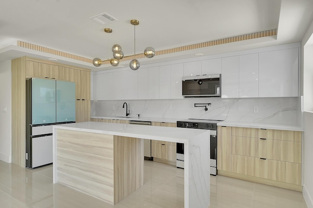 928 Market St, West Palm Beach, FL 33401 - kitchen with visible vents, appliances with stainless steel finishes, modern cabinets, light tile patterned floors, and light brown cabinets