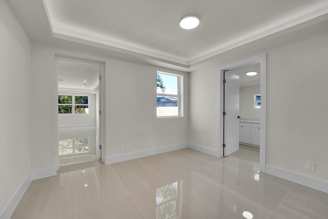 928 Market St, West Palm Beach, FL 33401 - spare room with baseboards, light tile patterned flooring, a tray ceiling, and a healthy amount of sunlight