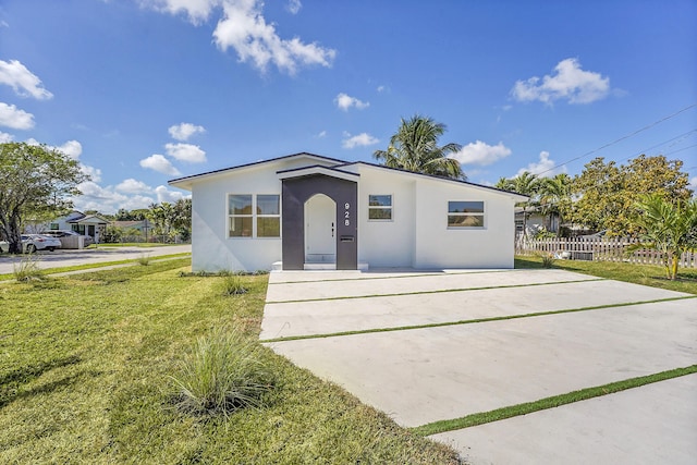 928 Market St, West Palm Beach, FL 33401 - view of front of home with fence, a front yard, and stucco siding