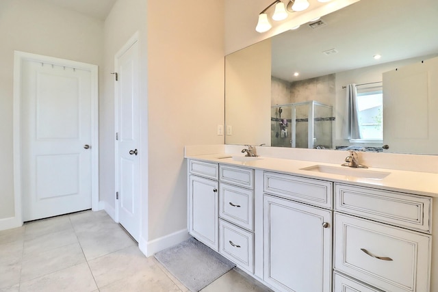 bathroom with a sink, double vanity, baseboards, visible vents, and a stall shower