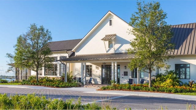 exterior space with a standing seam roof, a porch, and metal roof