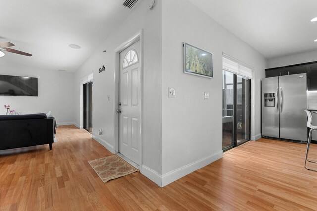 interior space featuring baseboards, a ceiling fan, light wood-type flooring, and visible vents