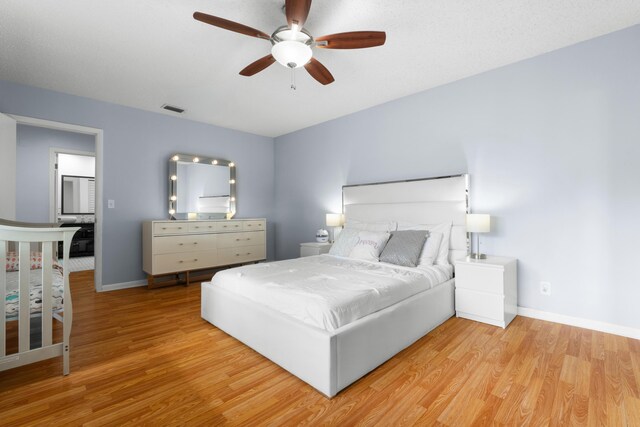 bedroom featuring visible vents, light wood-style flooring, ceiling fan, and baseboards