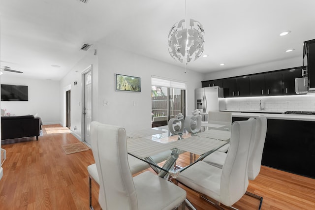 dining area with recessed lighting, visible vents, light wood-style flooring, and ceiling fan with notable chandelier