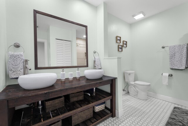 full bathroom with baseboards, vanity, and toilet