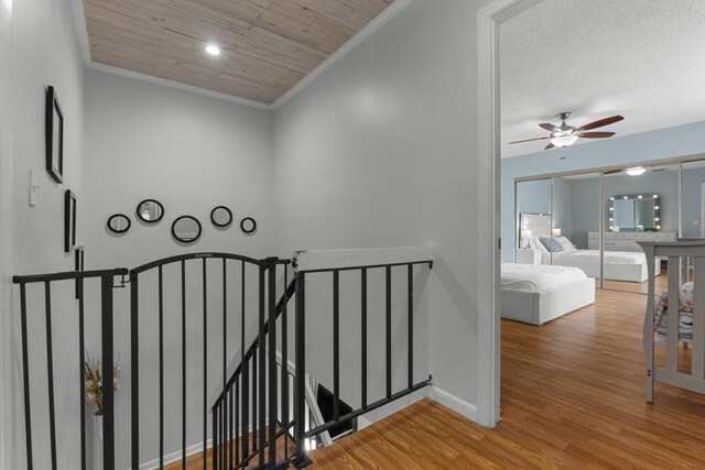 stairs with baseboards, ornamental molding, a ceiling fan, and wood finished floors