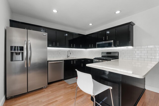 kitchen featuring dark cabinets, appliances with stainless steel finishes, and a sink