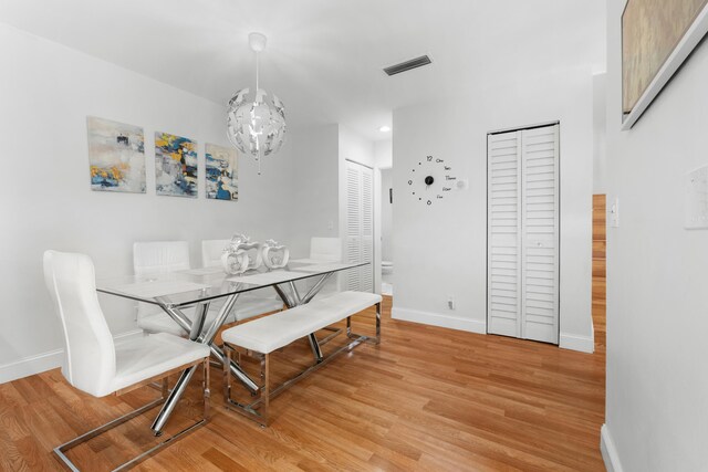 dining space with baseboards, visible vents, and light wood-style floors