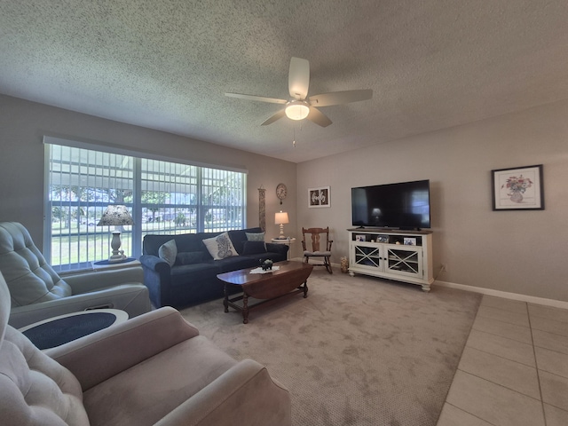 living area with baseboards, ceiling fan, carpet, and a textured ceiling