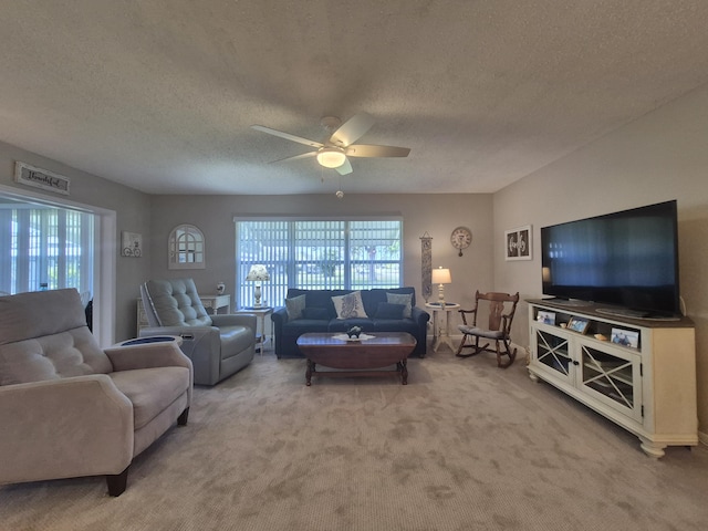 living area featuring visible vents, a textured ceiling, carpet, and ceiling fan
