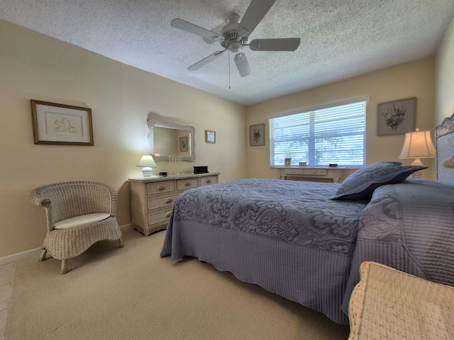bedroom featuring baseboards, ceiling fan, a textured ceiling, and light colored carpet