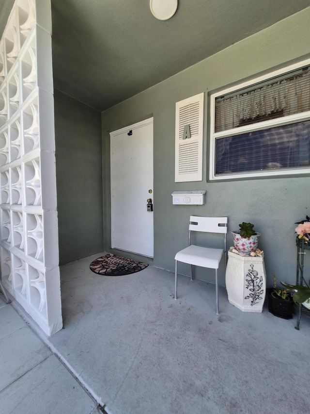 property entrance featuring a patio and stucco siding