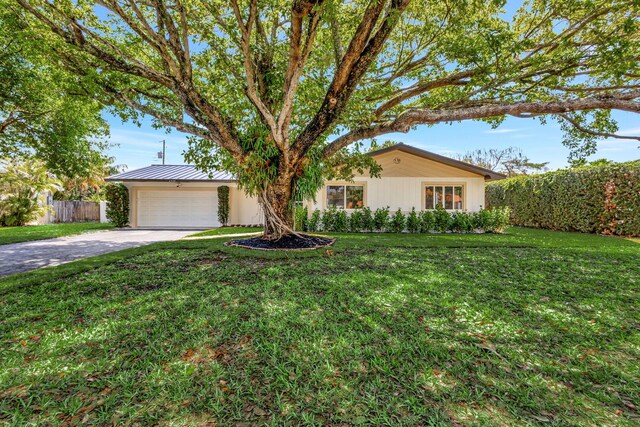 2410 SW 1st St, Boynton Beach, FL 33435 - single story home with a garage, fence, metal roof, concrete driveway, and a front yard
