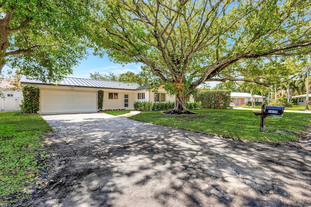 2410 SW 1st St, Boynton Beach, FL 33435 - single story home featuring a standing seam roof, an attached garage, stucco siding, aphalt driveway, and a front lawn