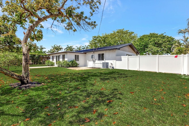 2410 SW 1st St, Boynton Beach, FL 33435 - back of house with cooling unit, fence, metal roof, a lawn, and a patio area