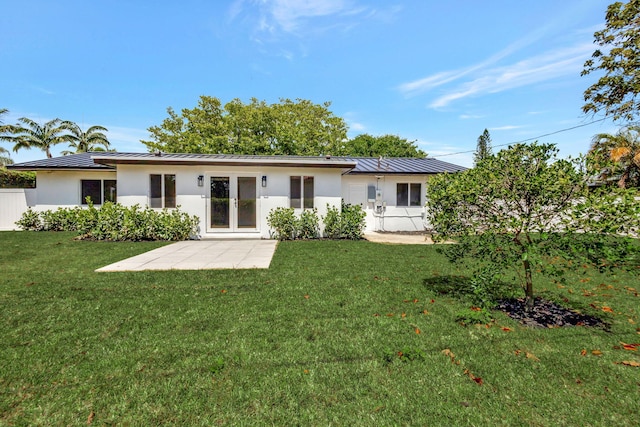 2410 SW 1st St, Boynton Beach, FL 33435 - back of house featuring metal roof, stucco siding, a standing seam roof, and a yard