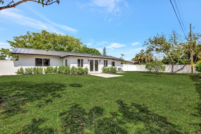 2410 SW 1st St, Boynton Beach, FL 33435 - rear view of house with fence, stucco siding, metal roof, a lawn, and a standing seam roof