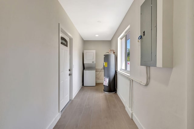 2410 SW 1st St, Boynton Beach, FL 33435 - hall with electric panel, water heater, stacked washer and dryer, light wood-style flooring, and baseboards