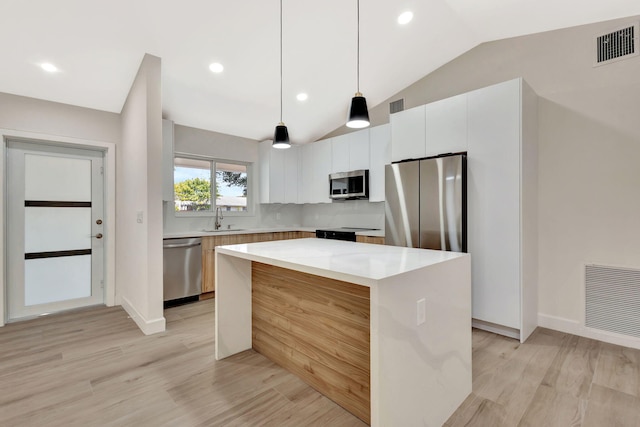 2410 SW 1st St, Boynton Beach, FL 33435 - kitchen featuring light wood finished floors, a sink, stainless steel appliances, visible vents, and vaulted ceiling