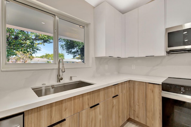 2410 SW 1st St, Boynton Beach, FL 33435 - kitchen with range with electric cooktop, modern cabinets, a sink, and stainless steel microwave