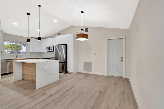 2410 SW 1st St, Boynton Beach, FL 33435 - kitchen featuring a sink, visible vents, vaulted ceiling, a kitchen island, and appliances with stainless steel finishes