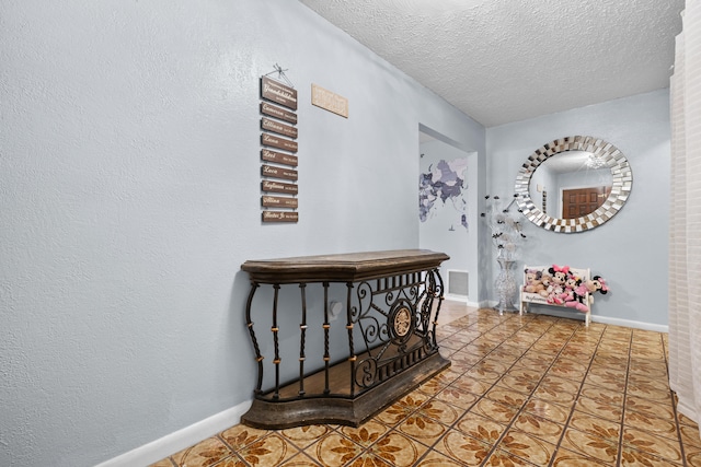 115 NE Caprona Ave, Port Saint Lucie, FL 34983 - hall featuring baseboards, tile patterned flooring, visible vents, and a textured ceiling