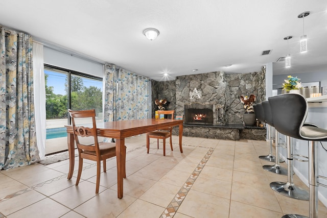115 NE Caprona Ave, Port Saint Lucie, FL 34983 - dining area with visible vents, a fireplace, and tile patterned flooring