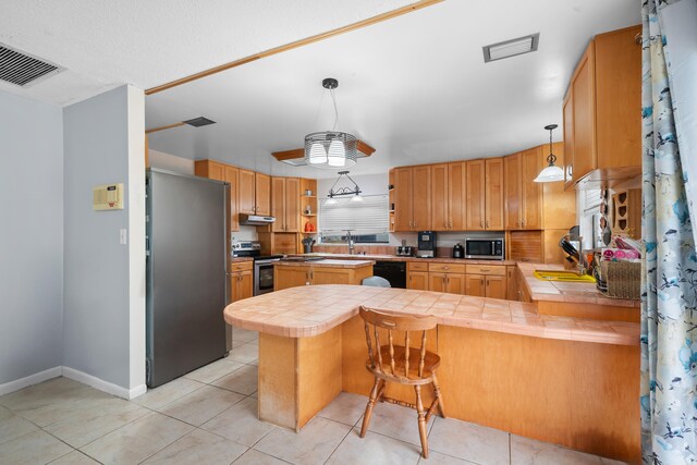 115 NE Caprona Ave, Port Saint Lucie, FL 34983 - kitchen with visible vents, a peninsula, open shelves, tile counters, and stainless steel appliances