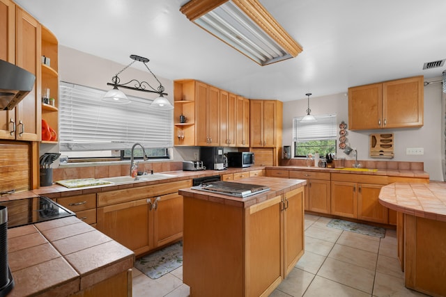 115 NE Caprona Ave, Port Saint Lucie, FL 34983 - kitchen with hanging light fixtures, a sink, open shelves, stainless steel appliances, and tile counters