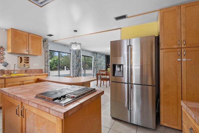 115 NE Caprona Ave, Port Saint Lucie, FL 34983 - kitchen with appliances with stainless steel finishes, light tile patterned flooring, tile countertops, and a sink