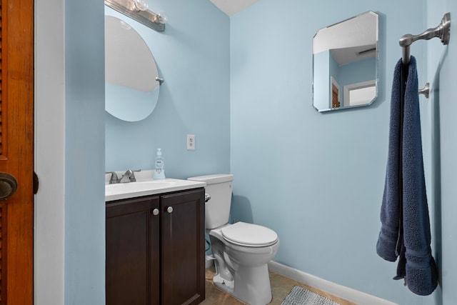 115 NE Caprona Ave, Port Saint Lucie, FL 34983 - half bathroom with toilet, baseboards, vanity, and tile patterned flooring