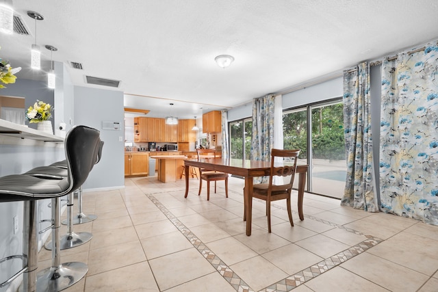 115 NE Caprona Ave, Port Saint Lucie, FL 34983 - dining room with light tile patterned floors, baseboards, visible vents, and a textured ceiling