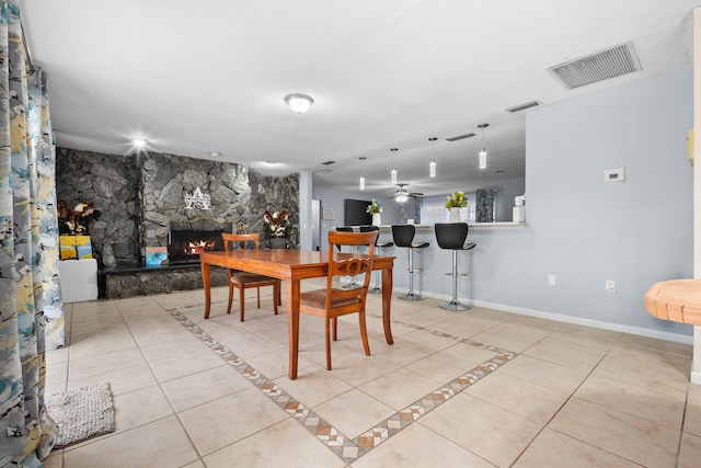 115 NE Caprona Ave, Port Saint Lucie, FL 34983 - tiled dining space featuring baseboards, ceiling fan, a fireplace, and visible vents