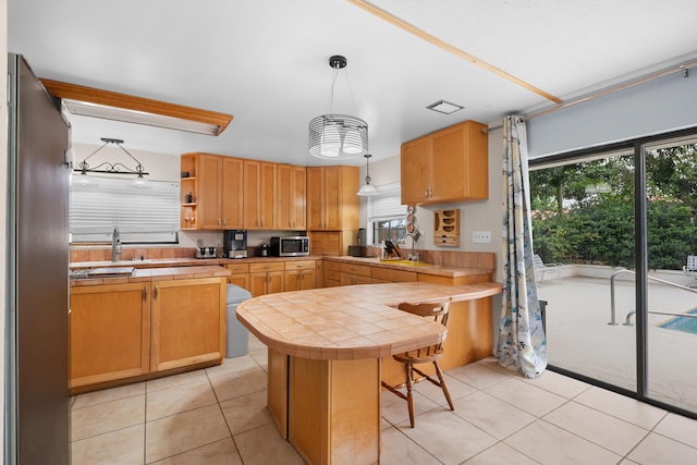 115 NE Caprona Ave, Port Saint Lucie, FL 34983 - kitchen with stainless steel appliances, a wealth of natural light, tile countertops, and light tile patterned floors