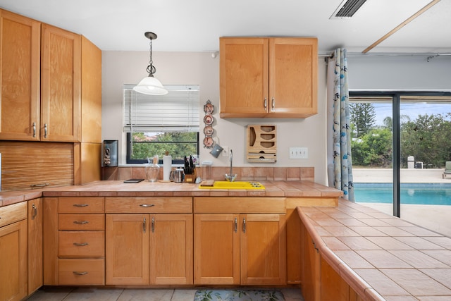 115 NE Caprona Ave, Port Saint Lucie, FL 34983 - kitchen featuring a sink, a wealth of natural light, tile countertops, and visible vents