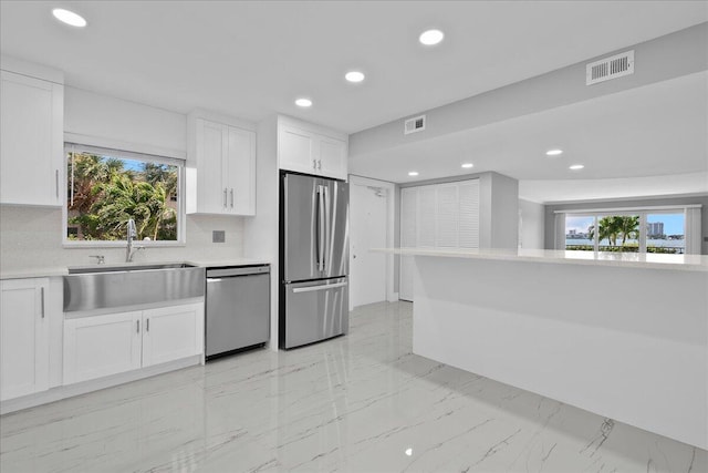 3040 Lake Shore Dr Unit 101, Riviera Beach, FL 33404 - kitchen featuring appliances with stainless steel finishes, a sink, light countertops, white cabinetry, and recessed lighting