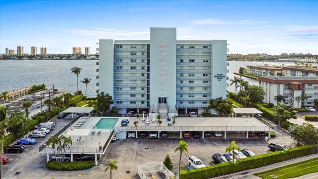 3040 Lake Shore Dr Unit 101, Riviera Beach, FL 33404 - view of building exterior with a view of city, uncovered parking, and a water view