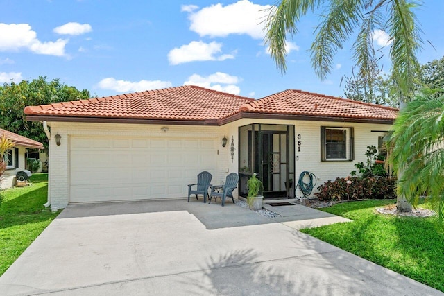 mediterranean / spanish-style home featuring brick siding, an attached garage, driveway, and a front lawn