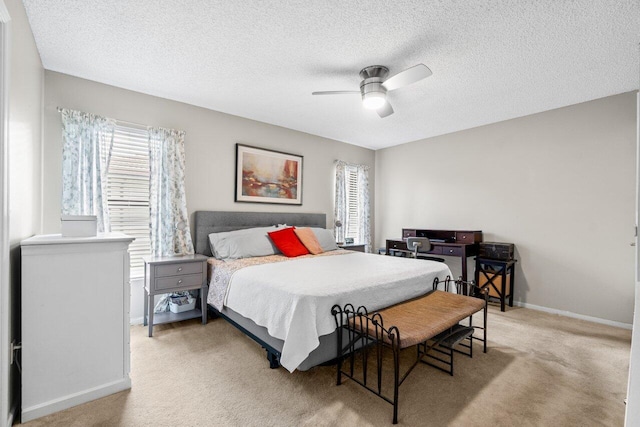 carpeted bedroom featuring baseboards, a textured ceiling, and ceiling fan