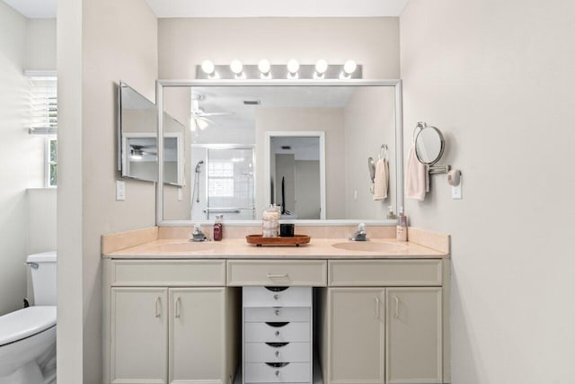 full bath featuring double vanity, a sink, a ceiling fan, and toilet