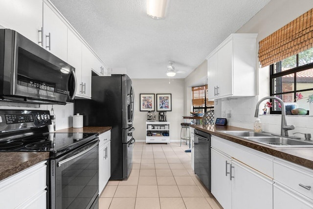 kitchen featuring white cabinets, dark countertops, a sink, a textured ceiling, and black appliances
