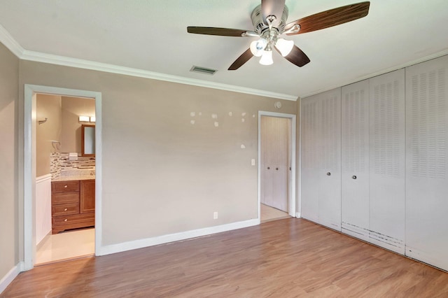 2867 Ashley Dr W Unit G, West Palm Beach, FL 33415 - unfurnished bedroom featuring crown molding, visible vents, connected bathroom, and light wood-type flooring