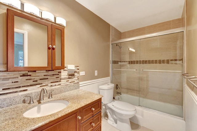 2867 Ashley Dr W Unit G, West Palm Beach, FL 33415 - bathroom with vanity, wainscoting, toilet, enclosed tub / shower combo, and backsplash