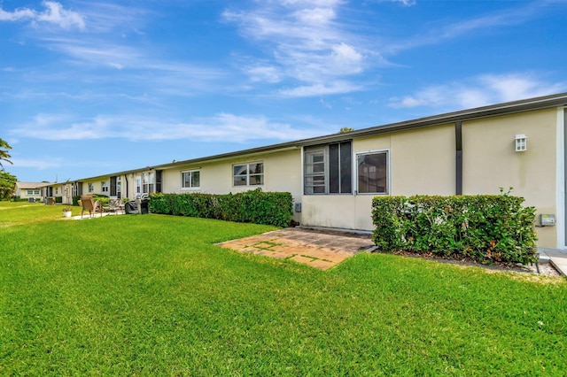 2867 Ashley Dr W Unit G, West Palm Beach, FL 33415 - rear view of house featuring a yard and stucco siding