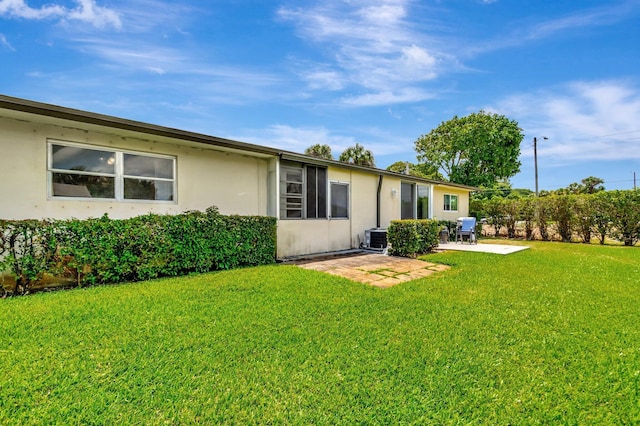 2867 Ashley Dr W Unit G, West Palm Beach, FL 33415 - back of property with a patio, a lawn, stucco siding, and central air condition unit