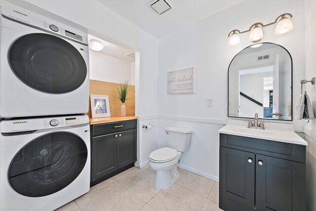 1420 Ocean Way Unit 30C, Jupiter, FL 33477 - bathroom with stacked washer / drying machine, tile patterned floors, toilet, vanity, and baseboards