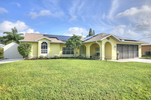 view of front facade with a garage, roof mounted solar panels, a front lawn, concrete driveway, and stucco siding
