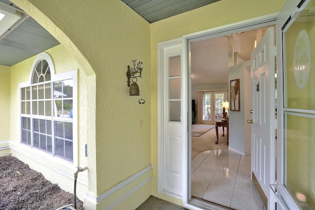 view of exterior entry featuring french doors and stucco siding